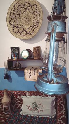 a blue lamp sitting on top of a table next to a wall mounted wicker basket