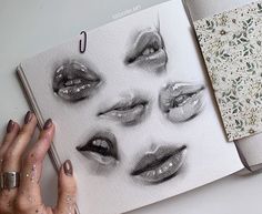 a woman's hand is holding an open book with drawings on it and the pages are covered in glitter