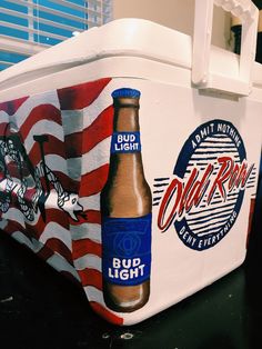 a cooler with an american flag design on the side and two beer bottles painted on it