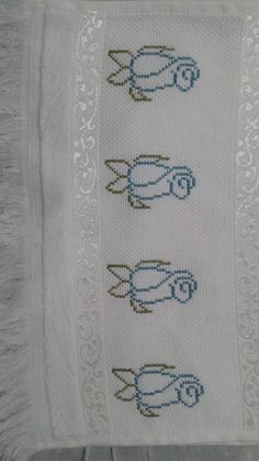 three crocheted cars on a white doily with blue and gold trimmings