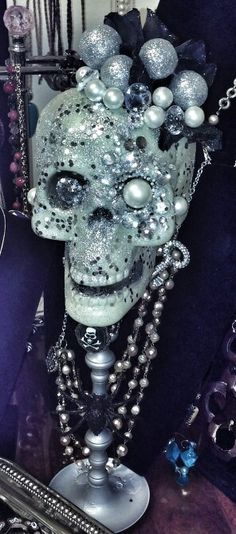 an odd looking mask with beads and chains on it's head is surrounded by other items