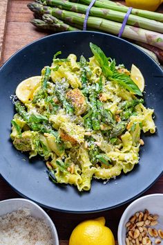 a blue plate topped with pasta and broccoli next to two bowls of rice