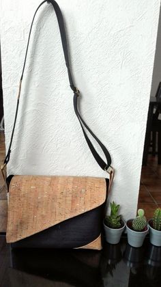 a black and brown purse sitting on top of a table next to potted plants