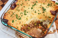 a casserole dish with meat, cheese and vegetables in it on a table