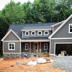 a house being built in the middle of a wooded area with lots of construction materials