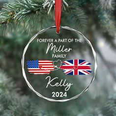 a personalized ornament hanging from a christmas tree with an american and british flag