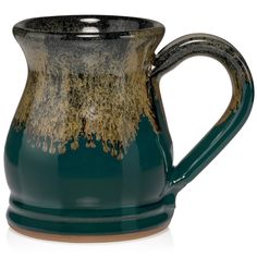 a green and brown ceramic pitcher on a white background