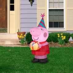 a large inflatable peppo pig wearing a party hat and holding a ball