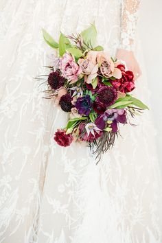 a bridal holding a bouquet of flowers in her hand