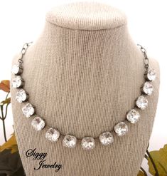 This dazzling Austrian crystal necklace showcases 12mm clear cushion cut genuine crystal elements in an antique silver plated chain.  This gorgeous statement piece is simply awe-inspiring and is a show stopper!! It looks fabulous on its own and even better layered with other pieces,  such as the Siggy 8mm necklaces and a Siggy thick, chunky chain.  The necklace is adjustable from 14-18 inches and features a large clasp and large link chain for easy fastening.    Matching cushion cut 12mm drop le Silver Crystal Jewelry With Cushion Cut, Fancy Cushions, Element Necklace, Woman Accessories, Stone Wedding, Large Stone, Swarovski Crystal Necklace, Crystal Choker, Indian Designer