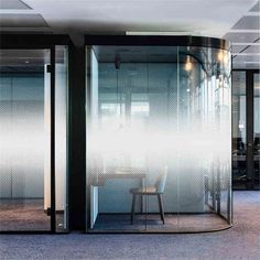 an office room with glass walls and chairs