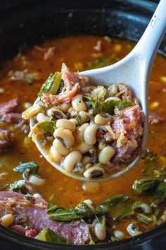 a spoon full of soup with beans and meat