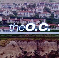 the o c logo is displayed in front of houses and cliffs with palm trees behind it