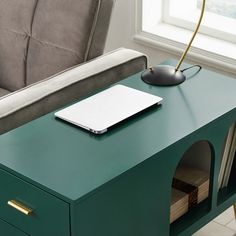 a laptop computer sitting on top of a green desk