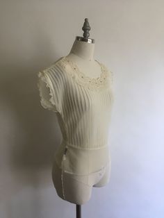 "Gorgeous sheer 1940's short sleeve nylon blouse with lace collar and rhinestones has pretty cap sleeves with a layer of pleated ruffle. Blouse zips up on the side and is in excellent vintage condition. Made by Debcraft and possibly one of the nicest nylon blouses I have come across! Shoulders 15\" Chest up to 36\" Waist 28\" Length from back of neck to hem 18\" Vintage garments have been previously worn and lovingly cared for, they may however have a blemish or two. Here at MadelonVintage, I tr Elegant Sheer Lace Top With Short Sleeves, Elegant Sheer Short Sleeve Lace Top, Fitted Sheer Lace Top With Short Sleeves, Stretch Lace Trim Short Sleeve Blouse, Fitted Vintage White Top, Fitted Lace Collar Top With Short Sleeves, Fitted Cream Top With Lace Collar, Fitted Vintage White Top For Daywear, Cream Fitted Top With Lace Collar