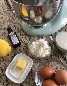 ingredients for making cake sitting on a counter top next to an electric mixer and eggs