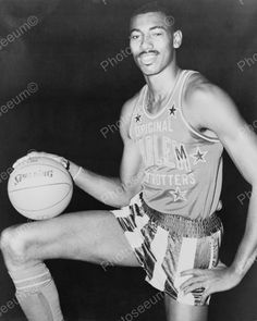 an old black and white photo of a man holding a basketball