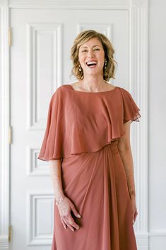 a woman in a dress smiling for the camera