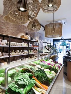 a store filled with lots of different types of vegetables on display in front of the counter