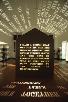 shadows cast on the wall and floor in an art gallery with words projected across it