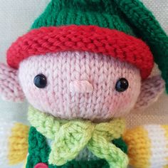 a knitted stuffed animal wearing a green and red hat