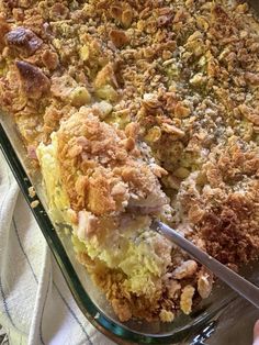 a casserole dish filled with stuffing and crumbs being cut by a knife