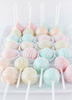 there are many different colored cake pops on the table