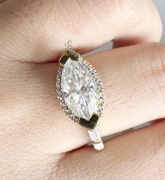 a woman's hand with a diamond and gold ring on top of her finger