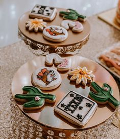 three tiered trays holding decorated cookies and pastries on top of a table