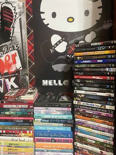 a pile of books sitting on top of a table next to a sign that says hello kitty