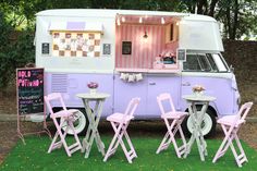 an ice cream truck is parked in the grass with pink chairs and tables set up outside