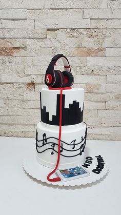 a three tiered cake with headphones on top and music notes around the edges