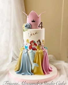 there is a three tiered cake with princesses on it and the number four