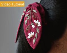 a woman wearing a red headband with white flowers on it