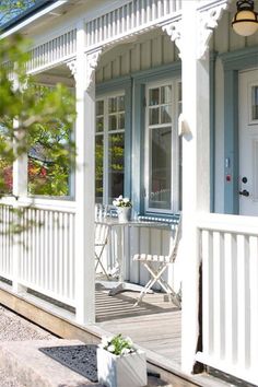 a white house with blue trim on the front porch