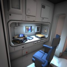 the interior of an airplane with blue chairs and electronic equipment on it's desk