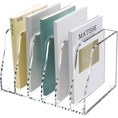 three different colored books in a clear holder