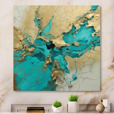 an abstract painting in gold and blue on a white wall above a fireplace mantel