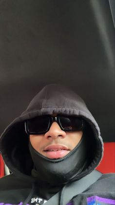 a man wearing sunglasses and a black hoodie