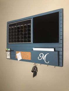 a bulletin board mounted to the wall with magnets on it and a key holder