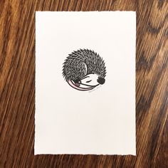 a piece of paper with a drawing of a hedgehog on it's side