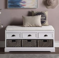 a white bench with baskets underneath it and a painting on the wall behind it in a living room