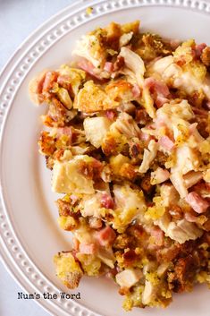 a white plate topped with lots of food on top of a table next to a fork