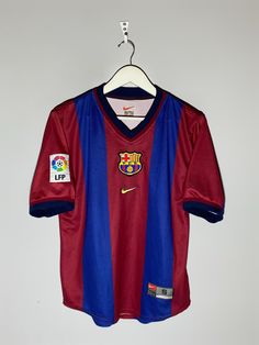 a red and blue soccer jersey hanging on a hanger