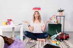 a woman sitting on the floor surrounded by toys