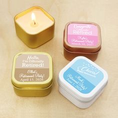 three small tins filled with candles sitting on top of a table