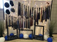 there are many ties hanging on the wall next to balloons and decorations for father's day