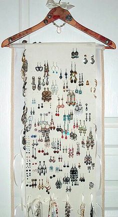 a white wall hanging with lots of earrings on it