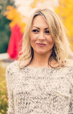 a woman with blonde hair smiling at the camera