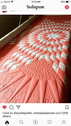 an orange and white quilt is laying on the floor in front of a bed frame